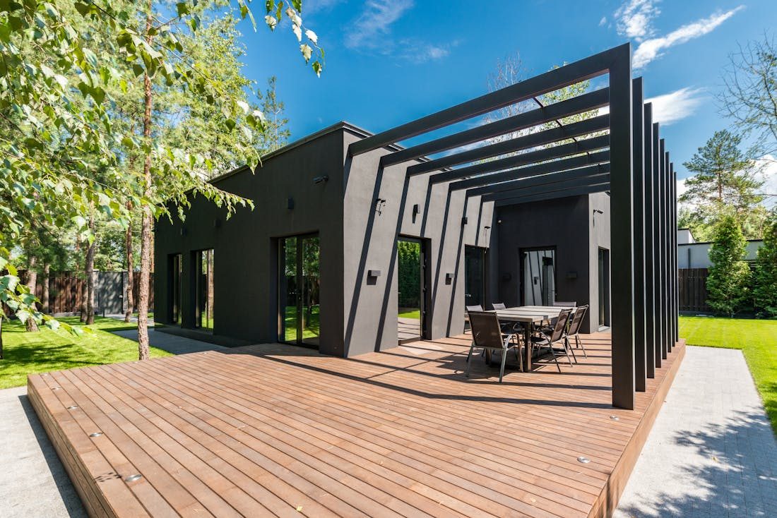 Custom wood deck with dining area surrounded by greenery
